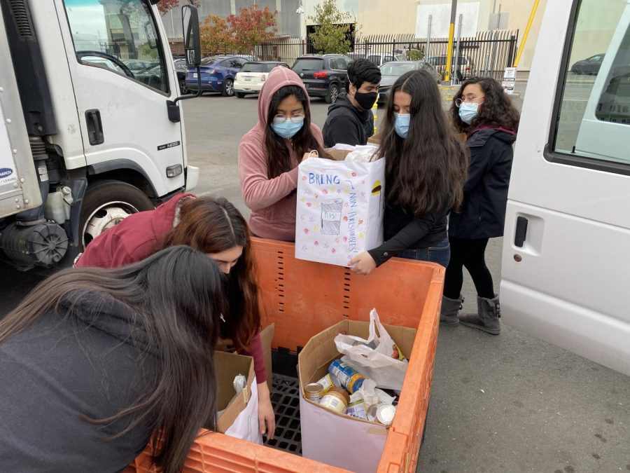 Seniors help unload a full van of donated food donated to the Ecumenical Hunger Program (EHP) in East Palo Alto after the Food Drive. (Photo courtesy of Linda Filo.) 