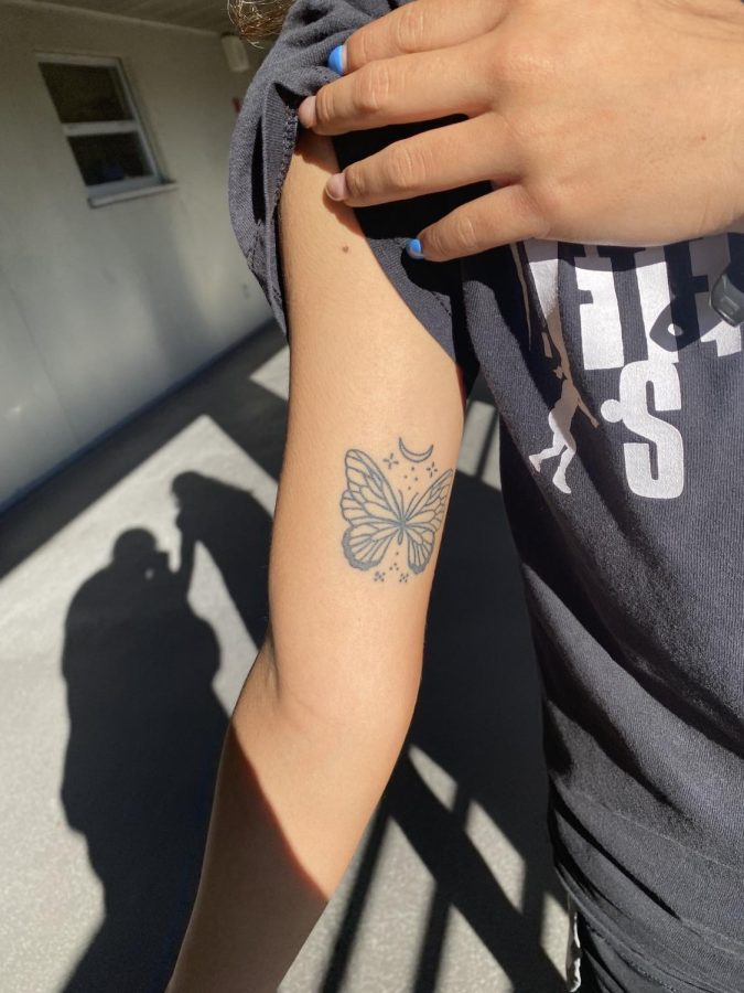 Senior Alondra Zamora showing her butterfly-and-moon tattoo.